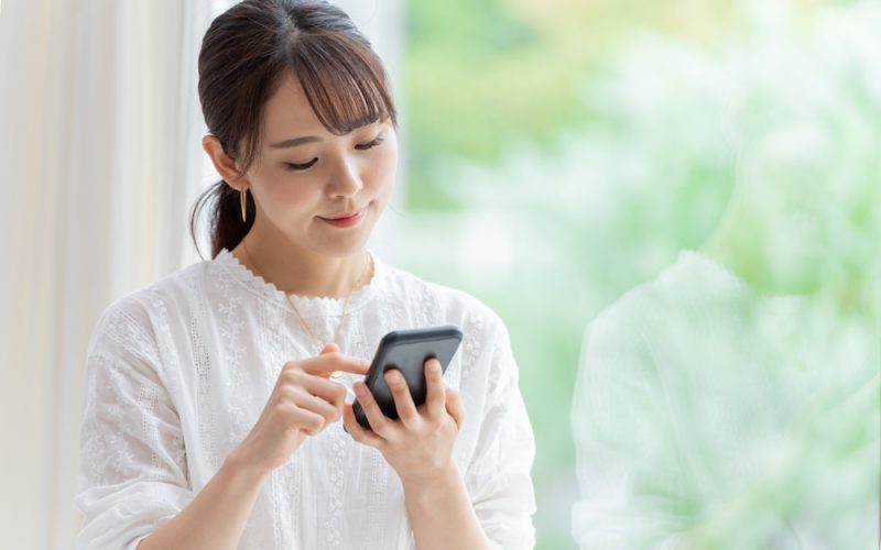 スマホを見て微笑む女性