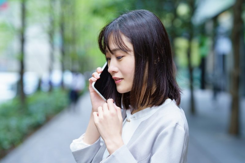 街中でスマートフォンで電話する女性