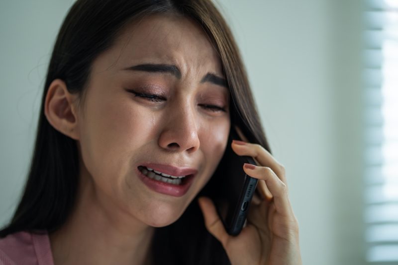 電話しながら泣く女性