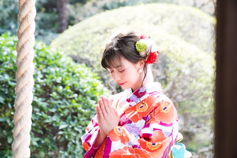 神社で祈る女性