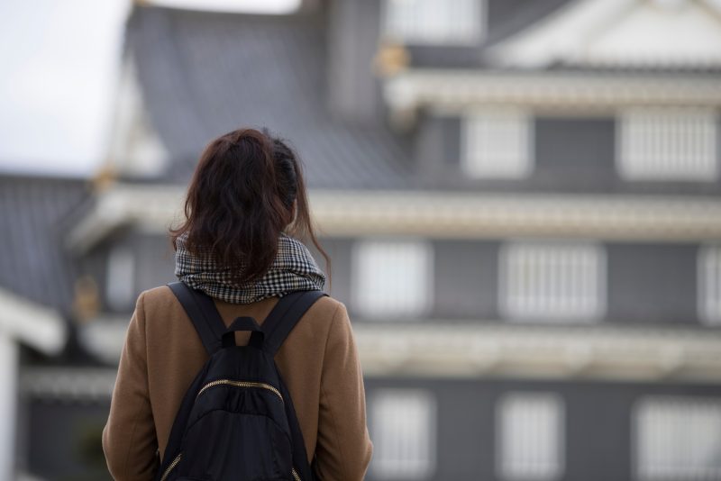 リュックを持った後ろ姿の女性